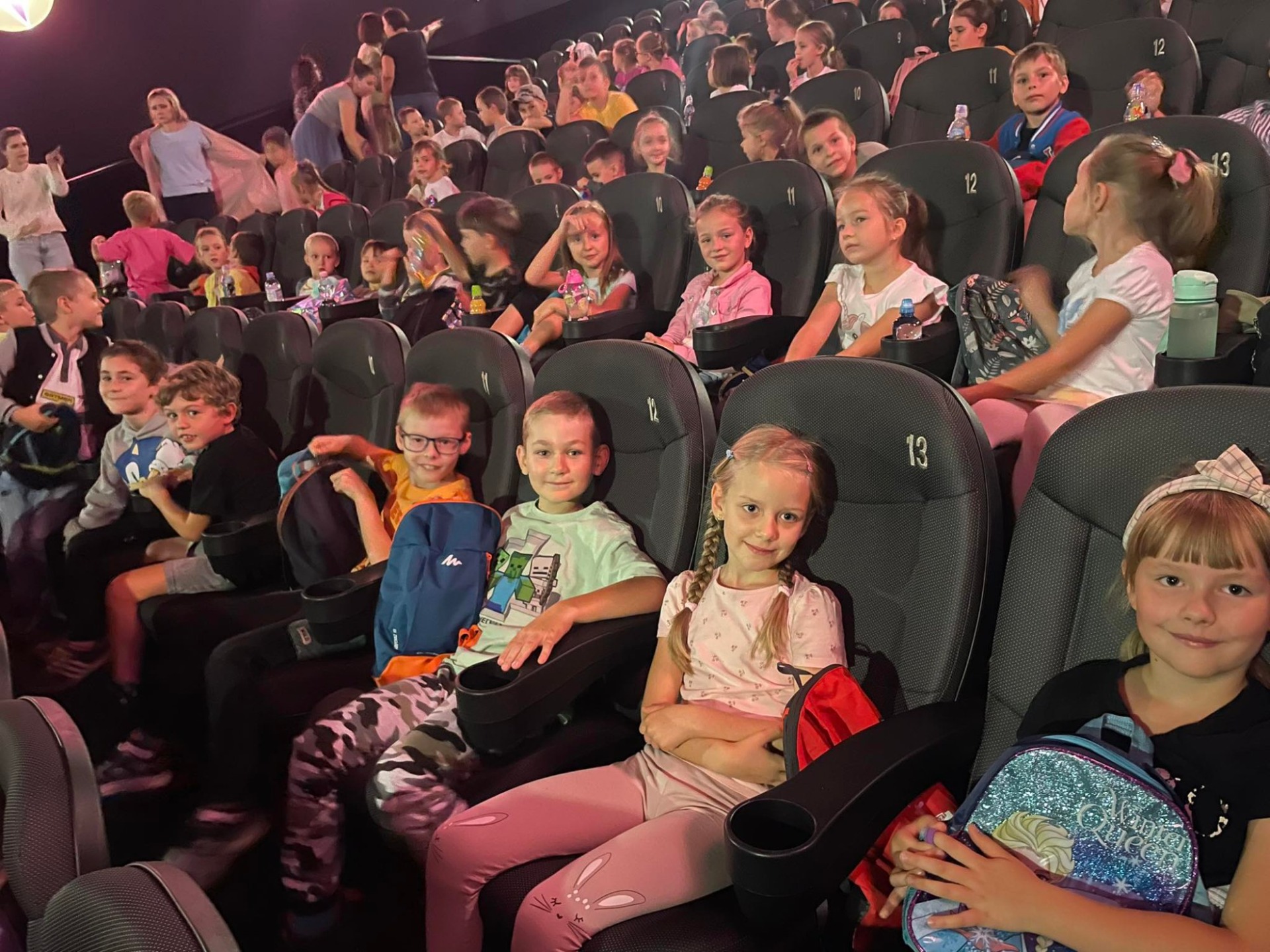 Dzieci siedzące w kinie i czekające na seans
