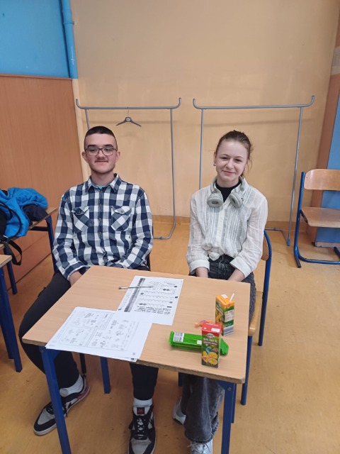 Dawid Cisowski i Oliwia Jachna siedzą przy stoliku konkursowym.