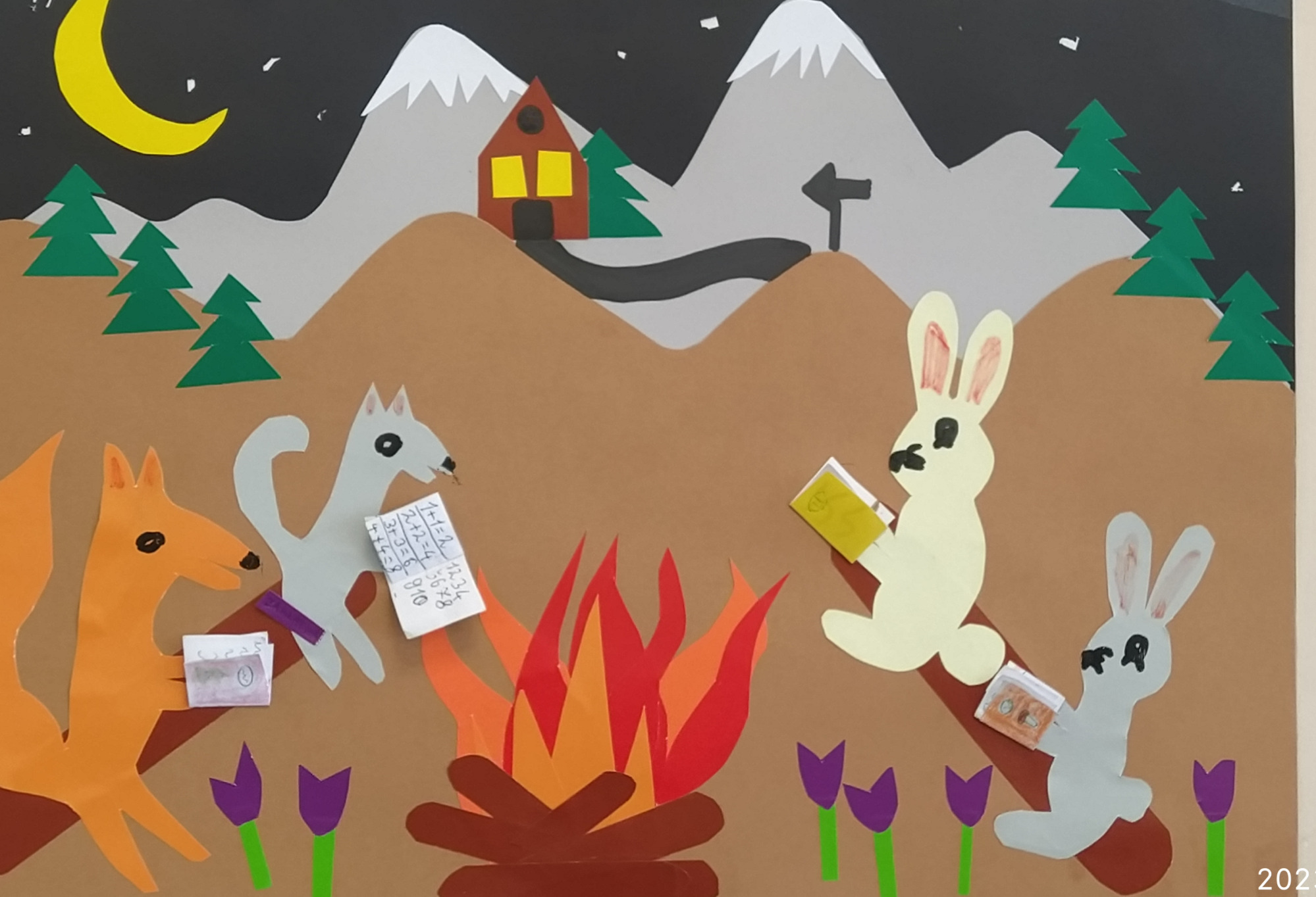 Zwycięska praca plastyczna – kolaż: noc w górach, przy ognisku zwierzęta leśne czytają książki.