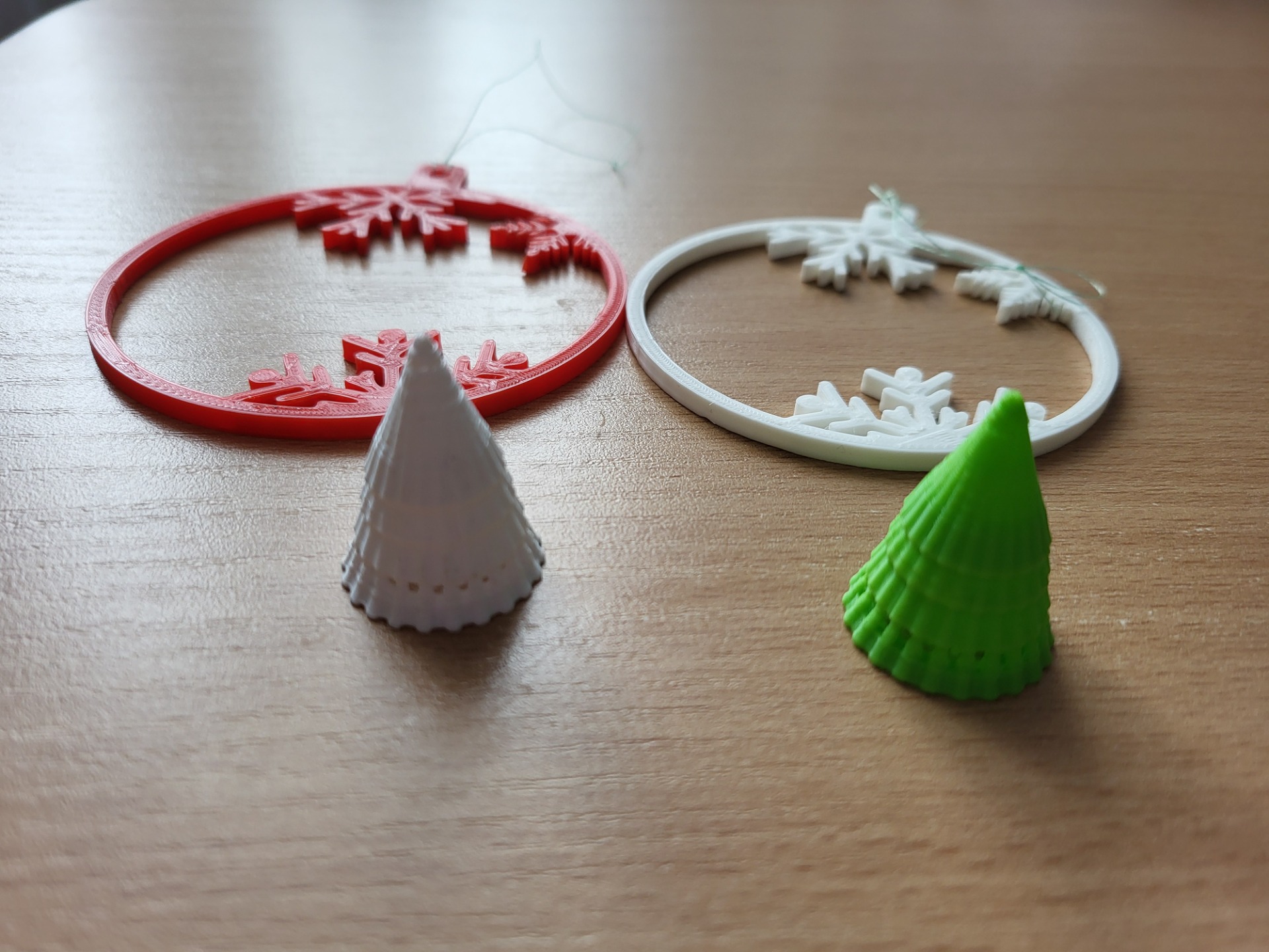 Czerwona i biała bombka oraz zielona i biała choinka wykonane za pomocą drukarki 3D.