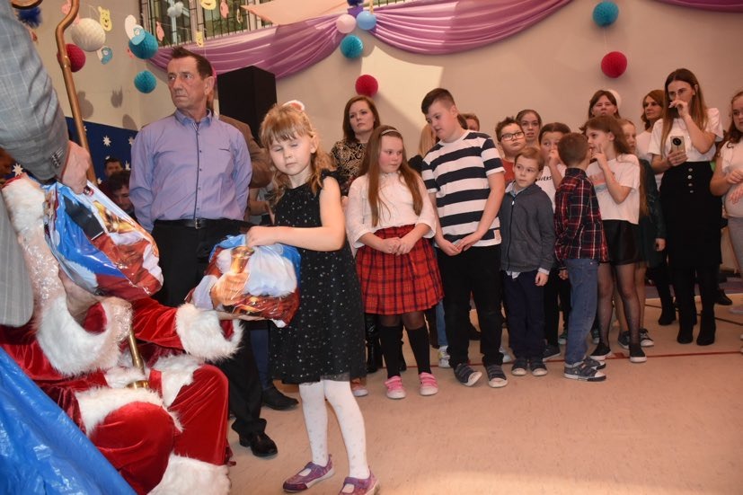 Mikołaj wręcza prezenty dzieciom w czasie Gminnej Choinki Noworocznej.