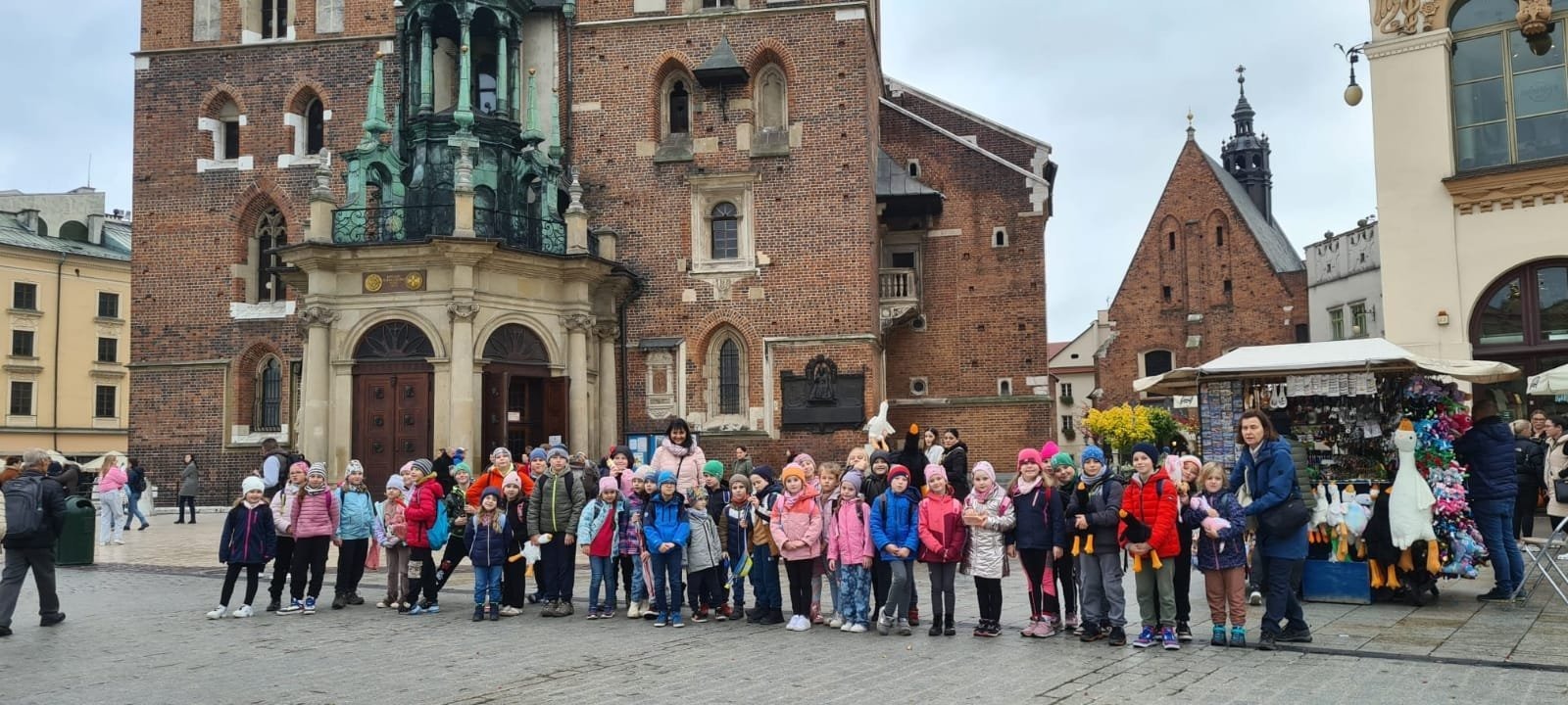Dzieci stoją przed Kościołem Mariackim na krakowskim Rynku