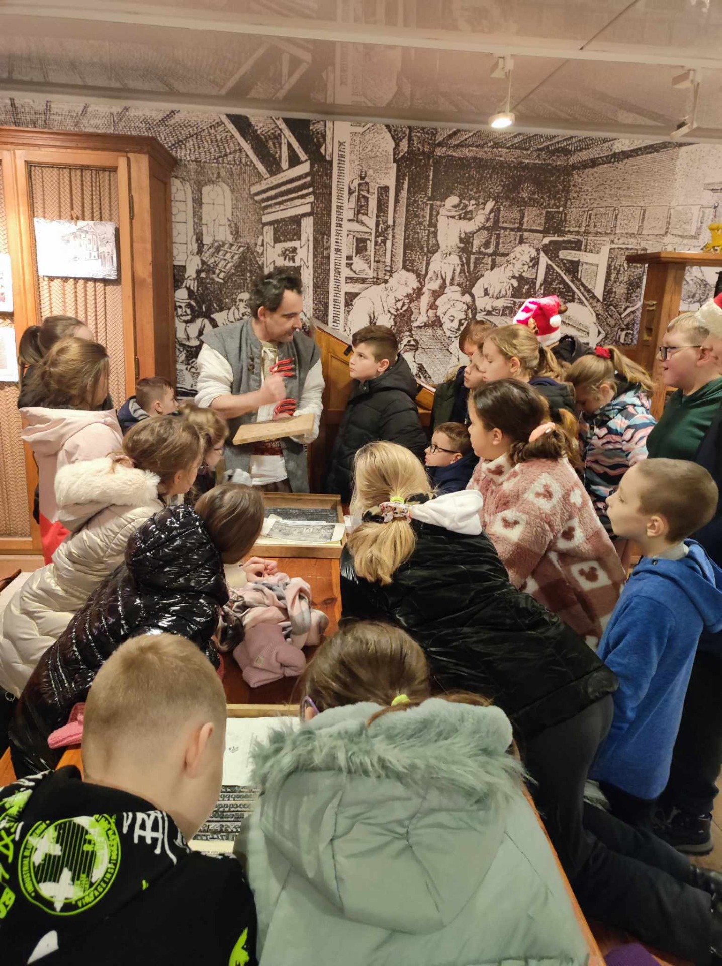 Grupa uczniów uczestniczy w warsztatach w pracowni w pałacu w Wilanowie.