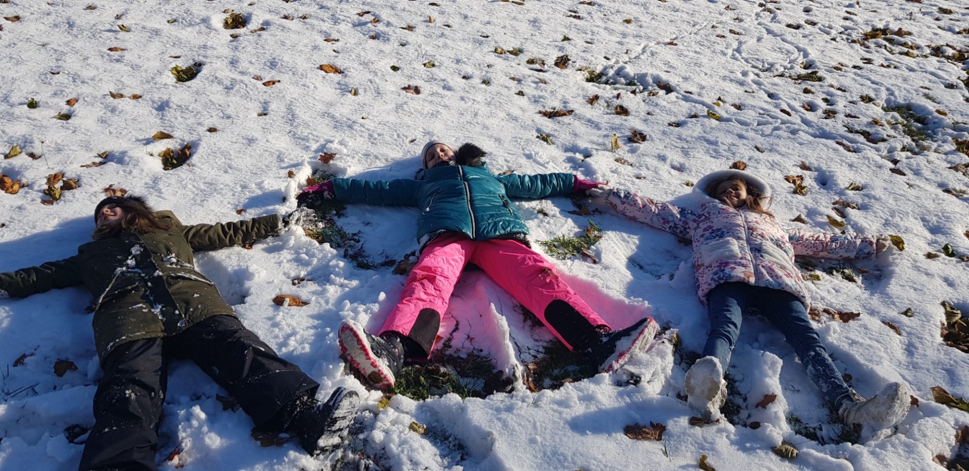 Dzieci tworzą ślady aniołka na śniegu 