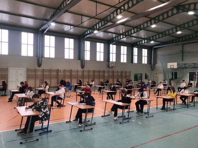 Uczniowie siedzą w ławkach podczas egzaminu próbnego