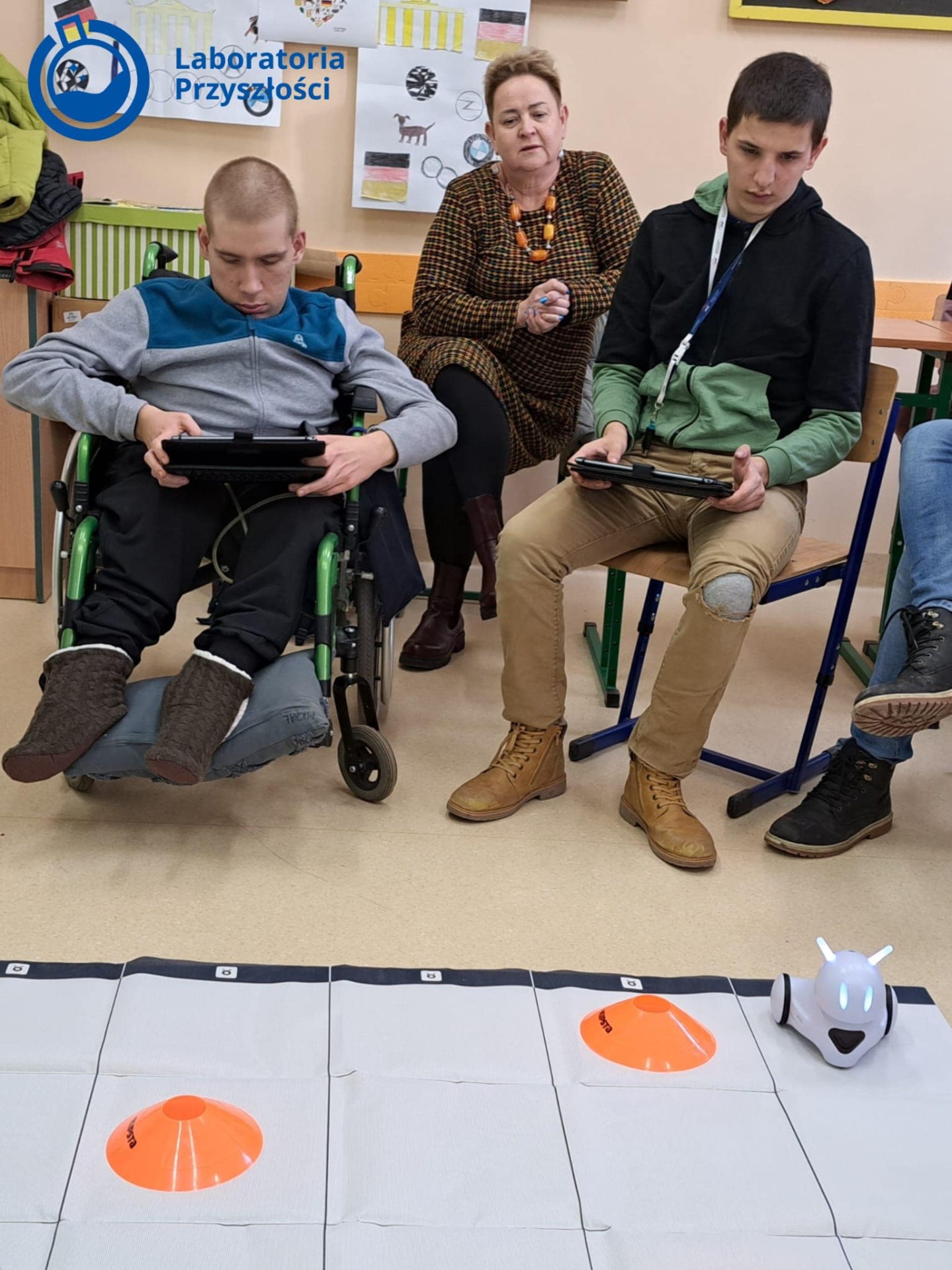 Michał i Norbert, uczniowie klasy 3 Szkoły Przysposabiającej do Pracy wraz z Panią Małgosią, podczas zajęć z robotami.