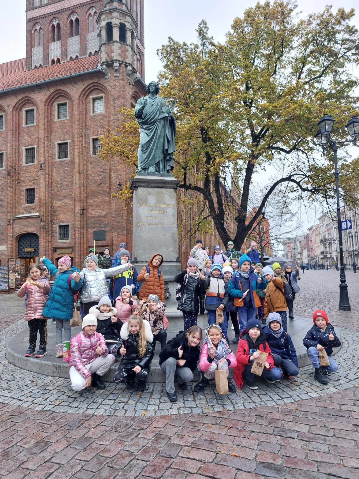 Uczniowie przy pomniku Mikołaja Kopernika