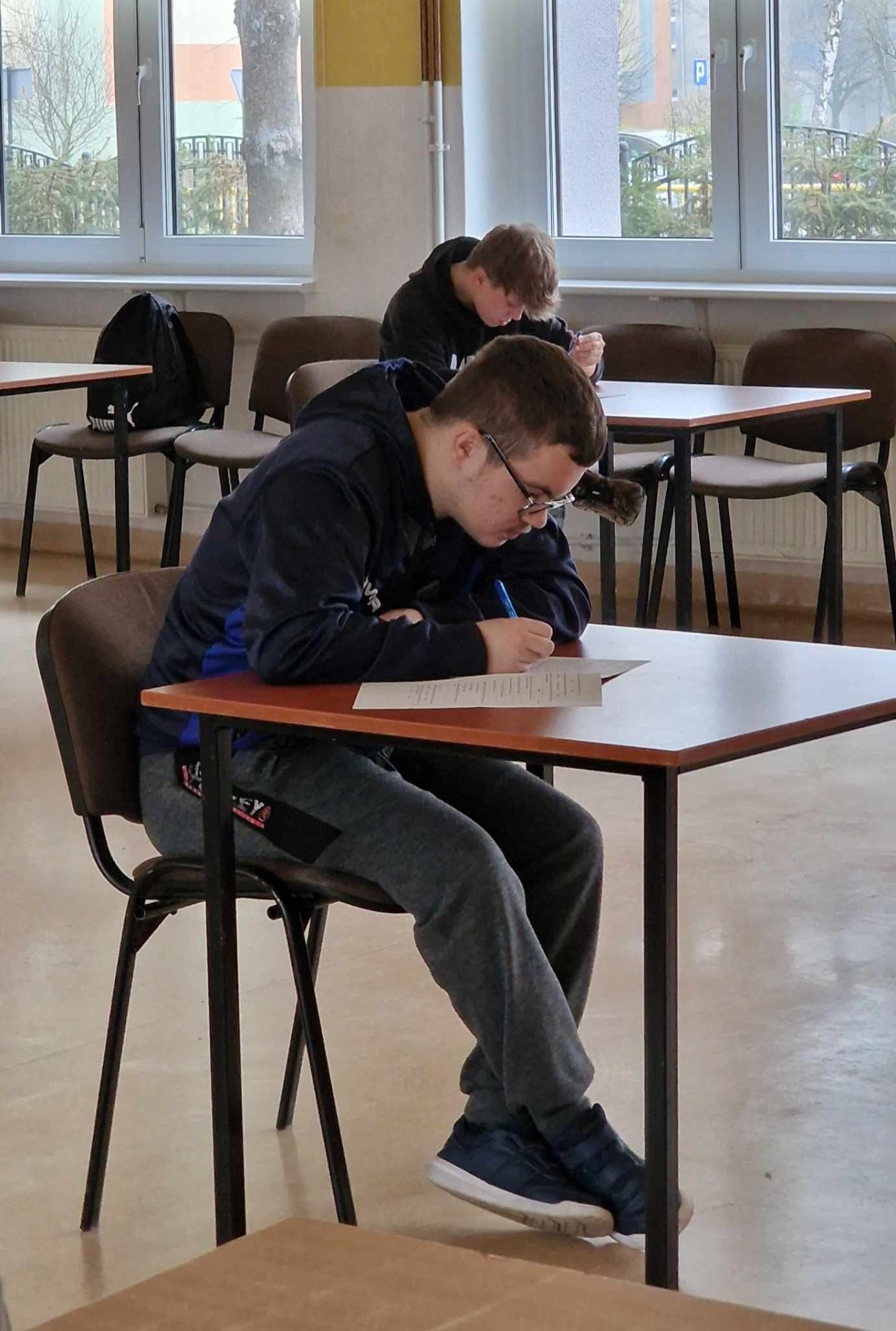 Uczeń rozwiązuje test, siedzi przy stoliku
