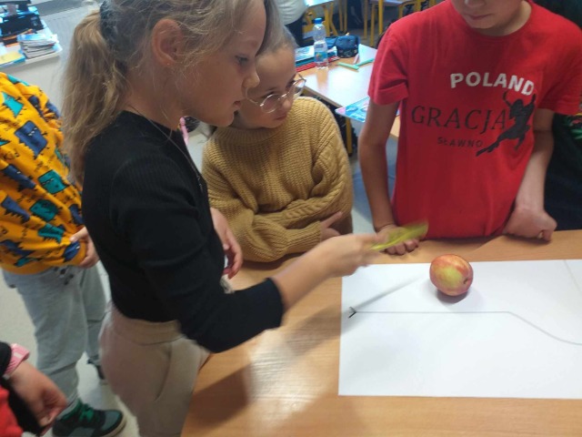 Dzieci turlają jabłko.